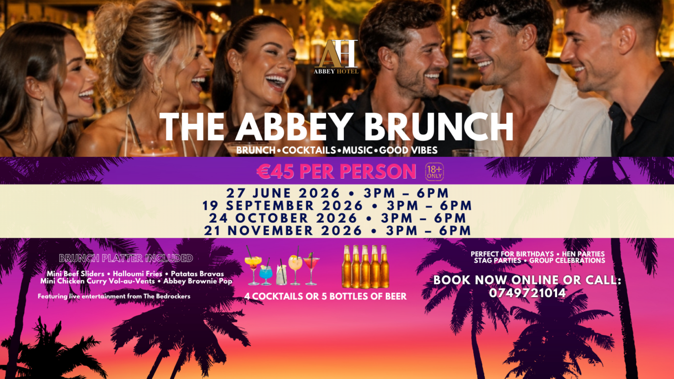 Happy guests enjoying vibrant brunch at Abbey Hotel with cocktails, delicious food, and lively atmosphere under warm lighting.